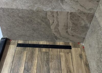 Душ зона с широкоформатни плочки на пода и линеен сифон в баня на сглобяема къща – Хубав дом