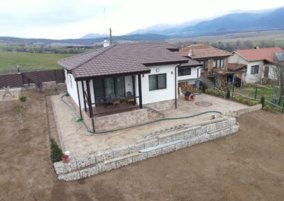 Фронтален въздушен изглед към сглобяема къща с веранда и гараж в с. Чавдар, реализирана от Хубав дом